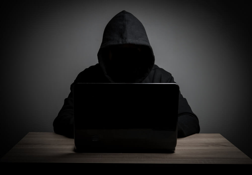 Cyber Security Expert wore Black Hoodie with Laptop on Table | TechReviewGarden