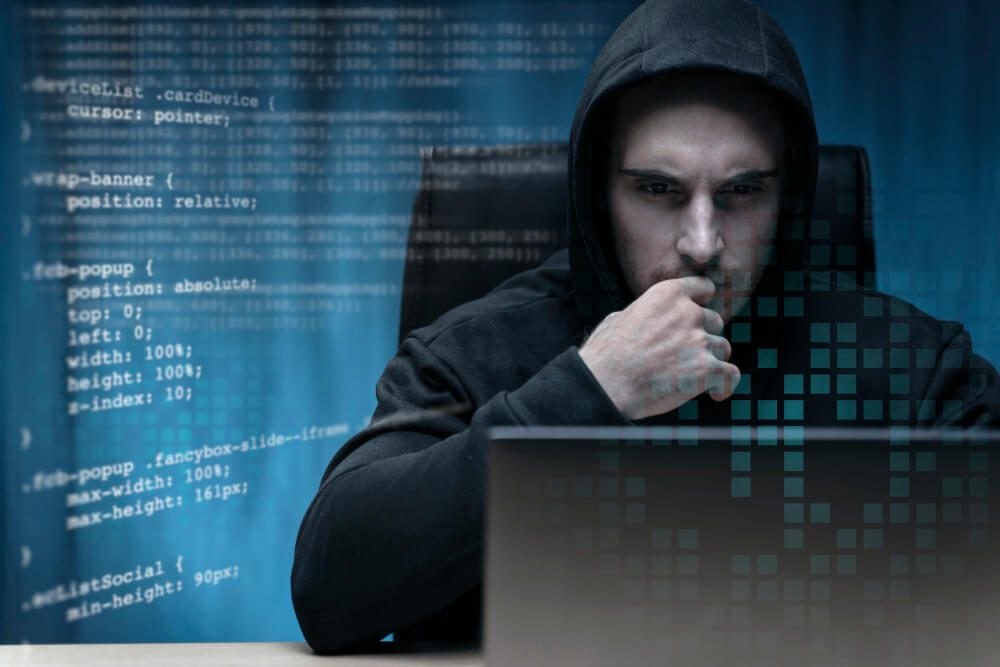 Cyber Security Expert wore Black Hoodie with laptop on Table and Code | TechReviewGarden